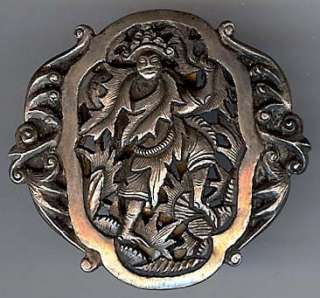 This ornate vintage dress clip of a man wearing leaves and seeming to 