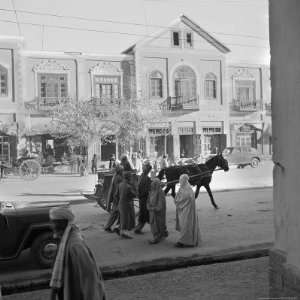  Men and Women, Wearing the Traditional Burqa, Walk Along a 