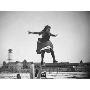  Young Edith Poey Jumping Off a Wooden Pole Onto the Sand 